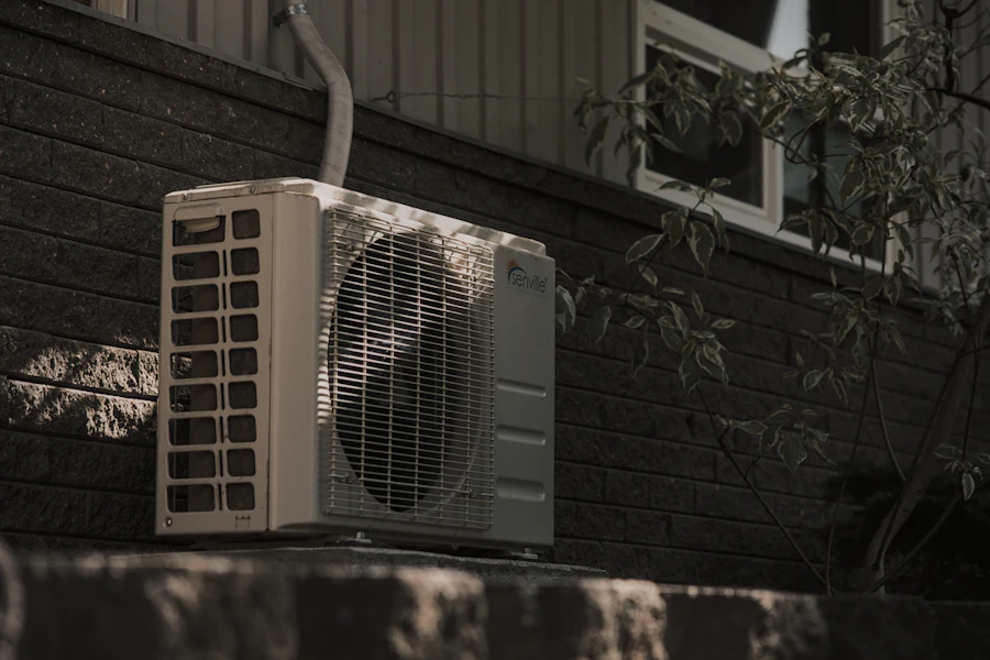 Outdoor AC condenser mounted against a brick wall